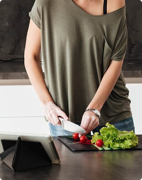 Woman chopping tomatoes on a chopping board